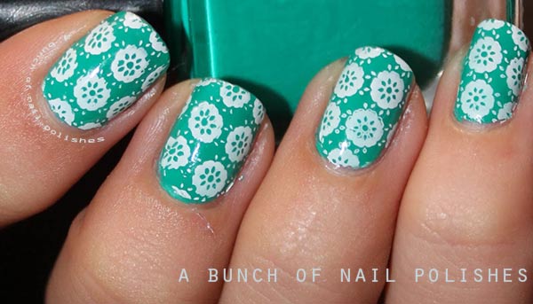 white flowers stamped on green nails